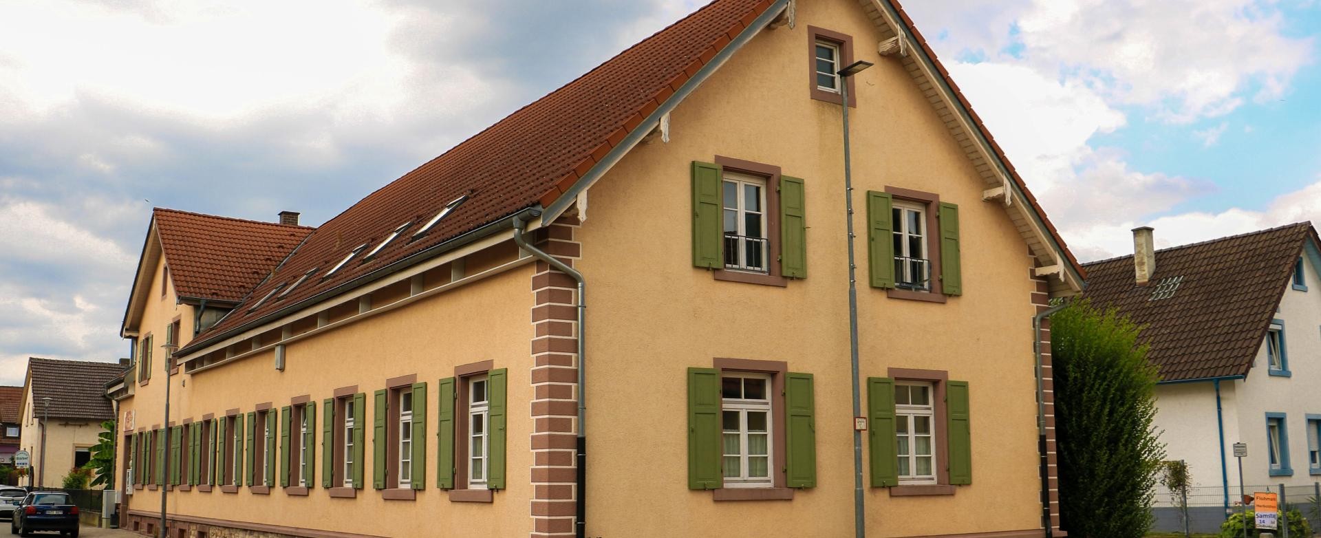 JuZe Rust Gebäude des JuZe Rust, ein langgestrecktes Gebäude in dunkelgelb mit lindgrünen Fensterläden