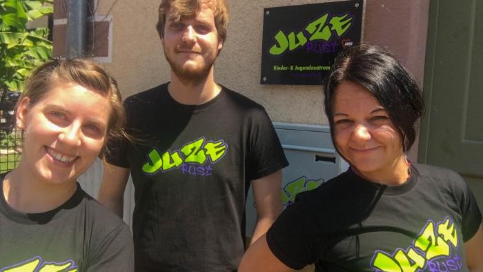 Team Juze Team Juze, links eine dunkelblonde Frau, in der Mitte ein junger Mann mit Bart und blonden Haaren, rechts eine schwarzhaarige Frau, alle tragen schwarze T-Shirts mit dem Schriftzug "Juze Rust"
